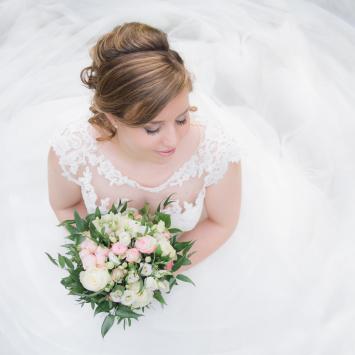 White woman in white wedding dress with flowers