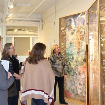 Megan Connor, Beth Garvin and Katie Cimet show Tami Gouveia the She4She Installation