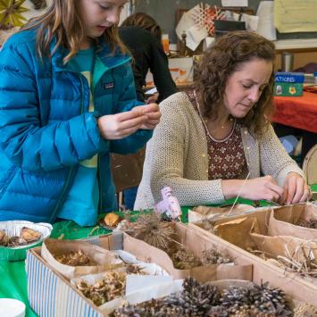 Child and adult making art out of found natural materials