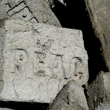 Adobe brick with the word PEACE pressed into it