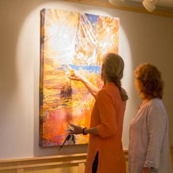 Two women looking at a painting